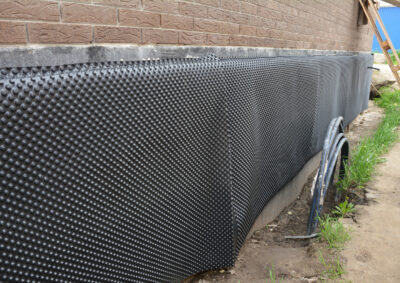 protecting-the-basement-foundation-outside-of-a-brick-house-from-water-and-moisture-using-a-foundation-waterproofing-dimpled-membrane-barrier-for-the-exterior-walls-house-foundation-waterproofing